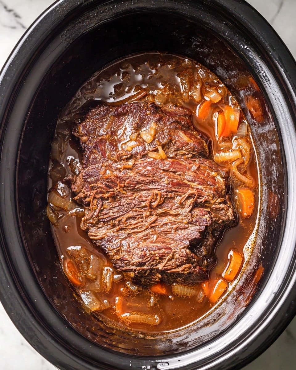 A dark brown cooked beef roast sits in the middle of a black slow cooker, covered with thick layers of cooked onions and orange carrot slices. The meat looks moist and tender, surrounded by a pool of rich brown gravy with small bubbles on the surface. The slow cooker has a shiny black interior with a smooth texture, contrasting with the soft, chunky texture of the meat and vegetables inside. The image is taken from above, centered on the roast in the cooker, showing the full inside of the pot against a white marbled background. photo taken with an iphone --ar 4:5 --v 7