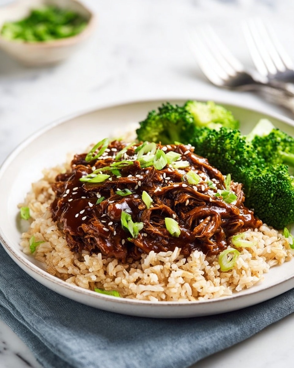 A white plate with three layers: the bottom layer is light brown rice with a soft, fluffy texture, covering the whole plate base. On top of the rice, in the center, is a thick layer of dark brown shredded meat coated in a glossy sauce, garnished with small white sesame seeds and bright green chopped scallions scattered evenly. On one side of the plate, there is a mound of bright green broccoli florets with a slightly shiny surface. The plate sits on a white marbled surface, with a metallic fork and a small bowl containing green herbs blurred in the background. Photo taken with an iphone --ar 4:5 --v 7