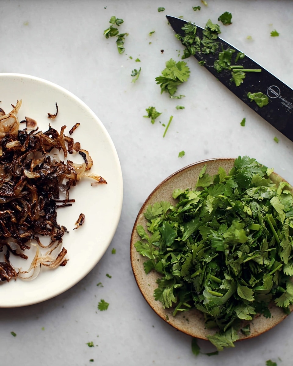 The image shows two white plates on a white marbled surface. The plate on the left has a layer of dark brown, crispy cooked onions scattered unevenly. The plate on the right contains a pile of chopped fresh green herbs, likely cilantro, with varied leaf shapes and textures. On the top right, there is a knife with chopped herbs stuck to its blade, resting on the surface with small herb pieces scattered around. The overall scene shows a preparation moment with fresh green and dark brown colors on a clean white marbled background. photo taken with an iphone --ar 4:5 --v 7