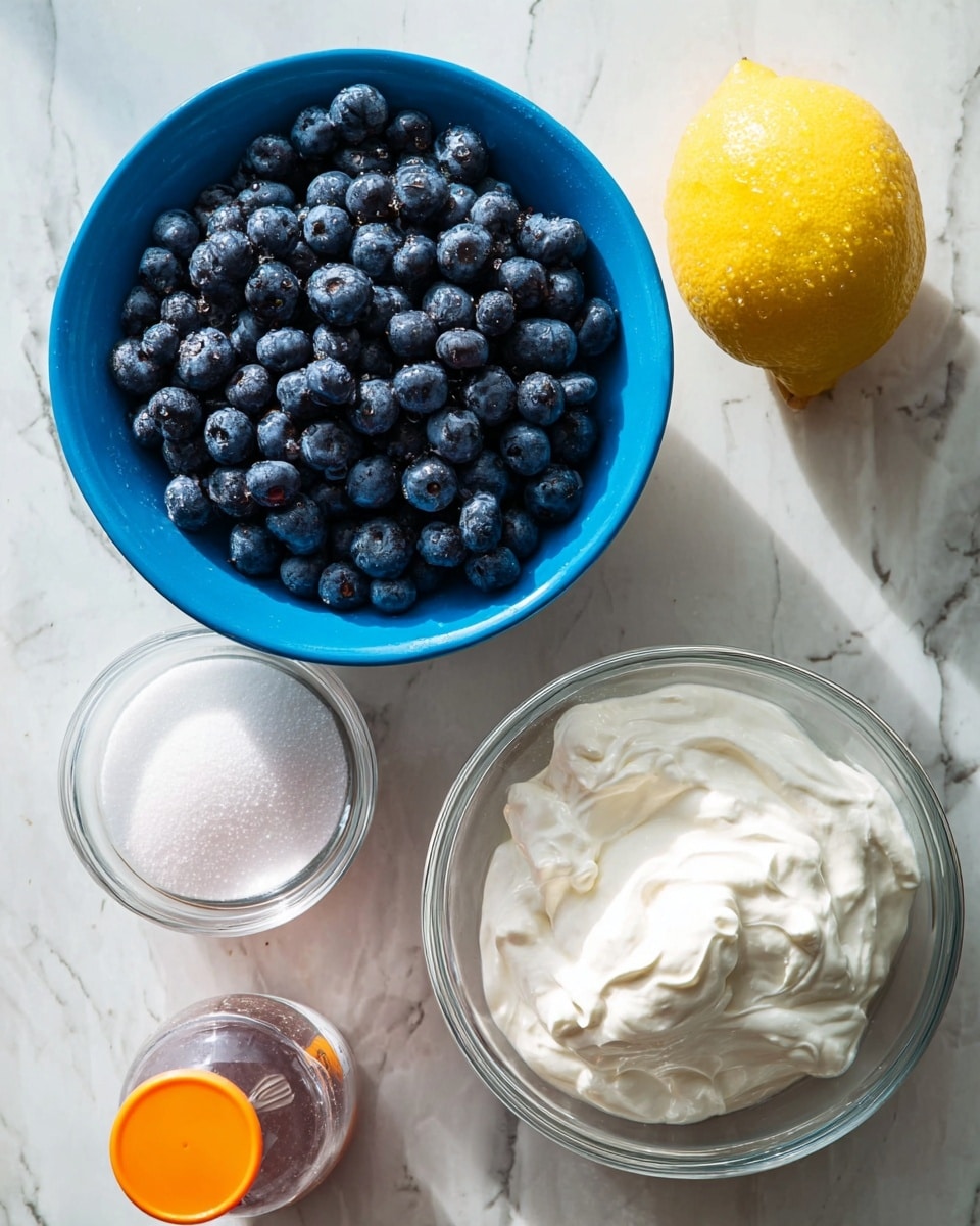 The image shows five items arranged on a white marbled surface: a blue bowl filled with many fresh, round blueberries with some water droplets on them at the top left, a bright yellow lemon to the right of the blueberries, a clear glass bowl of thick, white whipped cream below the lemon, a small clear bowl filled with white granulated sugar at the bottom left of the whipped cream, and a clear bottle with an orange cap positioned to the left of the sugar. The scene is brightly lit with natural light, emphasizing the fresh textures and colors of the ingredients. Photo taken with an iphone --ar 4:5 --v 7