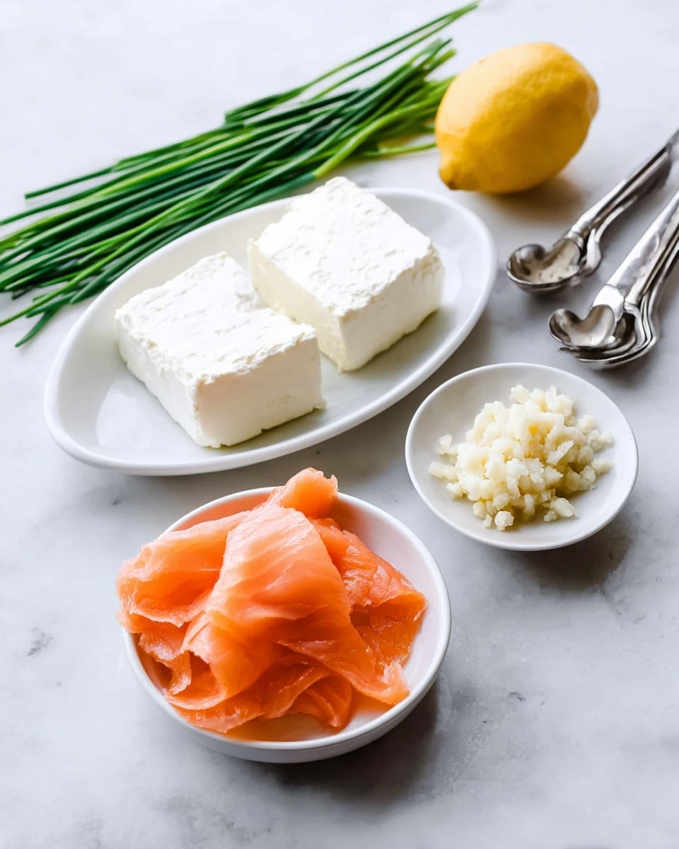 The image shows a white oval plate with two thick, creamy white blocks of cream cheese placed side by side on a white marbled surface. In front of this plate is a small white bowl filled with thin, bright orange slices of smoked salmon that look soft and slightly folded. To the right is a small white round dish holding a small mound of pale beige minced garlic. Scattered around the dishes are fresh, dark green chives, and a yellow lemon sits in the background next to a set of silver measuring spoons. The overall look is clean and fresh with a simple arrangement. photo taken with an iphone --ar 4:5 --v 7