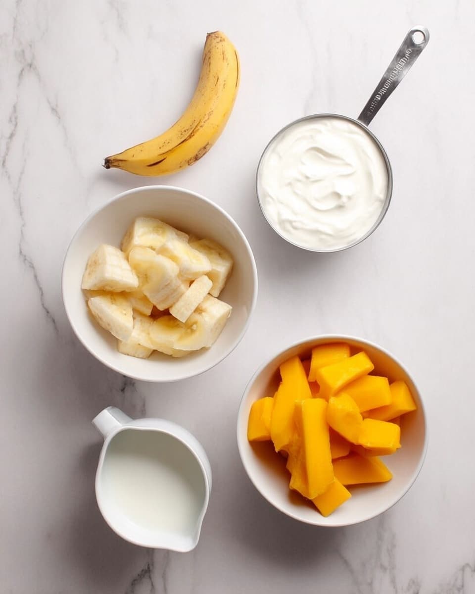 The image shows four white containers arranged on a white marbled surface. At the top right, there is a metal measuring cup filled with smooth white yogurt or cream. Below it, slightly to the right, is a white bowl filled with bright orange mango chunks with a peeled banana placed on top. To the left of it, there is another white bowl containing pale yellow frozen fruit pieces. At the bottom left, there is a small white pitcher filled with a white liquid, likely milk or cream. photo taken with an iphone --ar 4:5 --v 7