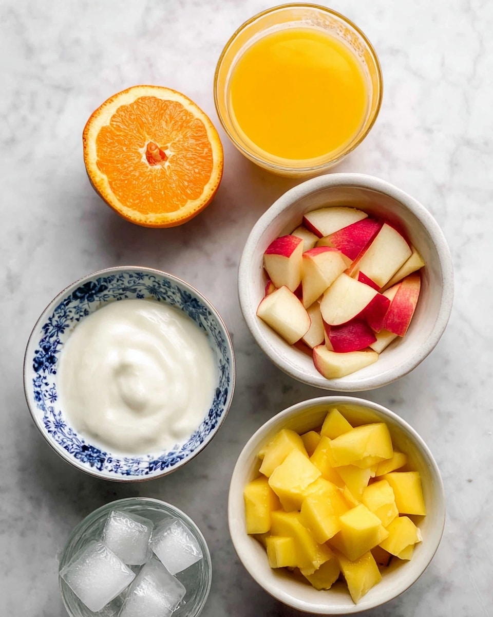 The image shows five small bowls arranged on a white marbled surface. The top left area has a halved orange and a small clear glass container filled with bright orange juice. To the right, there is a white bowl with red-skinned apple pieces cut into small chunks. Below it, a white bowl with a blue floral pattern is filled with smooth, thick white yogurt. On the left side, underneath the orange, a white bowl holds yellow mango cubes with a firm texture. At the bottom left, a white bowl contains clear ice cubes with a glossy surface. The setup looks fresh and colorful, with fruits, yogurt, ice, and juice ready for making a cold fruit treat. Photo taken with an iphone --ar 4:5 --v 7