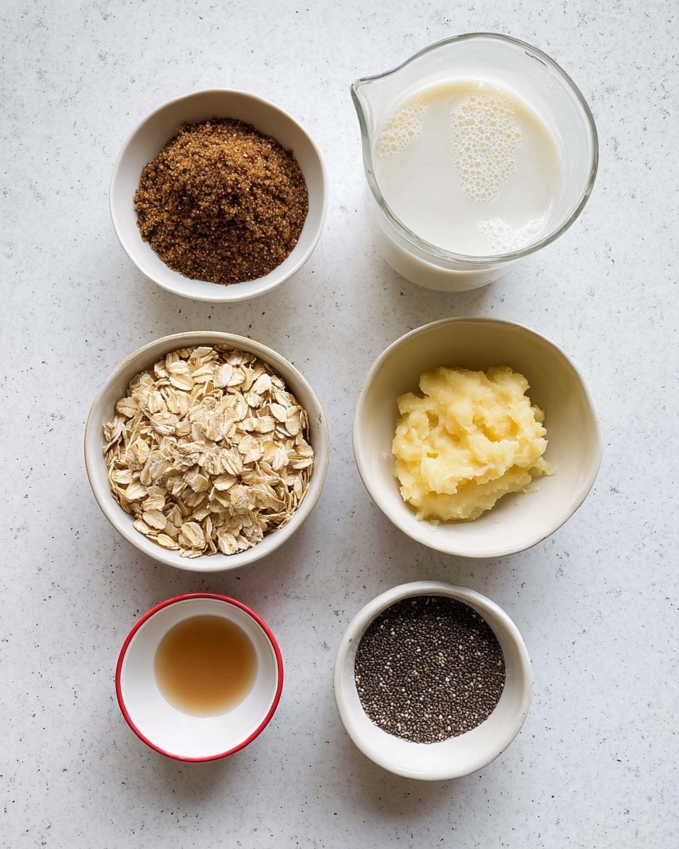 The image shows six small white bowls arranged on a white marbled surface. The top left bowl is filled with dark brown sugar with a grainy texture. To the right, a clear glass jug contains white milk, showing small bubbles on top. Below the jug, a white bowl holds a pale yellow, soft mashed banana with a slightly creamy texture. Centered below the brown sugar, a larger white bowl is full of light brown rolled oats with a rough and flaky texture. Below the banana bowl, a tiny white bowl contains a light brown liquid, likely vanilla extract. On the bottom left, a half white and half red bowl contains small amounts of white salt and brown ground cinnamon. The bottom right has a medium white bowl filled with tiny black chia seeds with a slightly shiny surface. Photo taken with an iphone --ar 4:5 --v 7