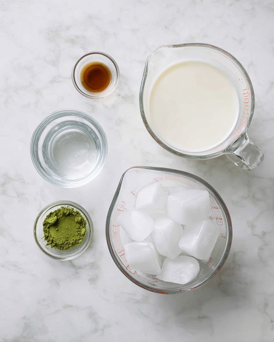The image shows five clear glass bowls and measuring cups placed on a white marbled surface, each holding different ingredients. In the center is a medium clear glass bowl filled with large ice cubes, which are white and transparent with smooth edges. Above the ice, slightly right, is a large measuring cup with white milk, smooth and creamy in texture, filling most of the cup. To the left of the milk is a smaller clear glass measuring cup filled with clear water, smooth and reflective. Below the water is a small clear bowl holding a small pile of green matcha powder, finely textured and vibrant in color. To the left of the matcha powder, near the top left corner, is another small clear bowl with a small amount of brown liquid, smooth and glossy. Photo taken with an iphone --ar 4:5 --v 7