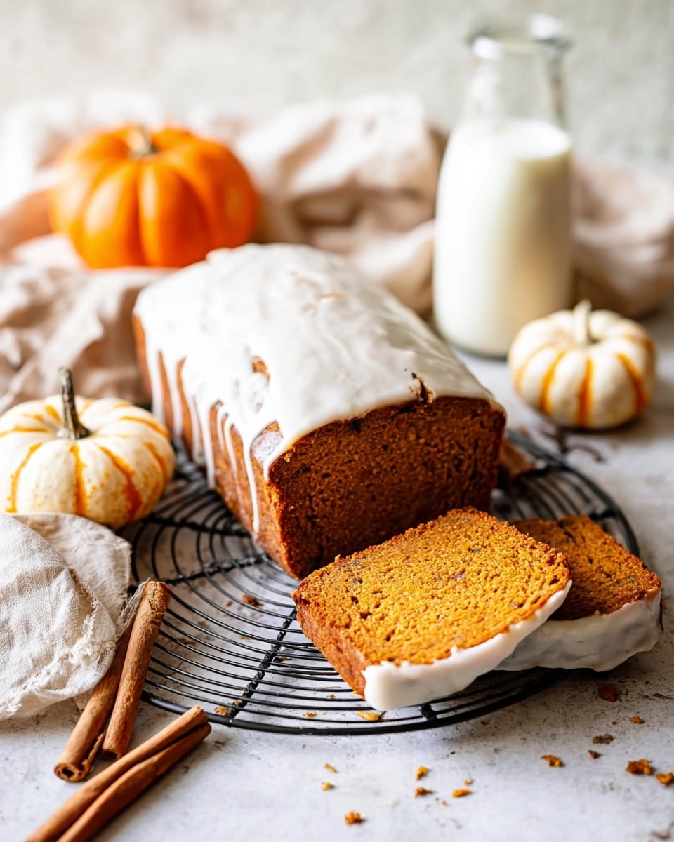 A loaf of pumpkin bread sits on a round black wire cooling rack on a white marbled surface, with two slices taken from the front. The pumpkin bread is rich orange-brown in color, with a thick, creamy white icing layer spread over the top and slightly dripping down the sides. Around the bread are small orange and white pumpkins, and two cinnamon sticks lie nearby. Behind the bread, there is a glass bottle filled with milk and a soft beige linen cloth softly folded. The lighting is soft and natural. photo taken with an iphone --ar 4:5 --v 7