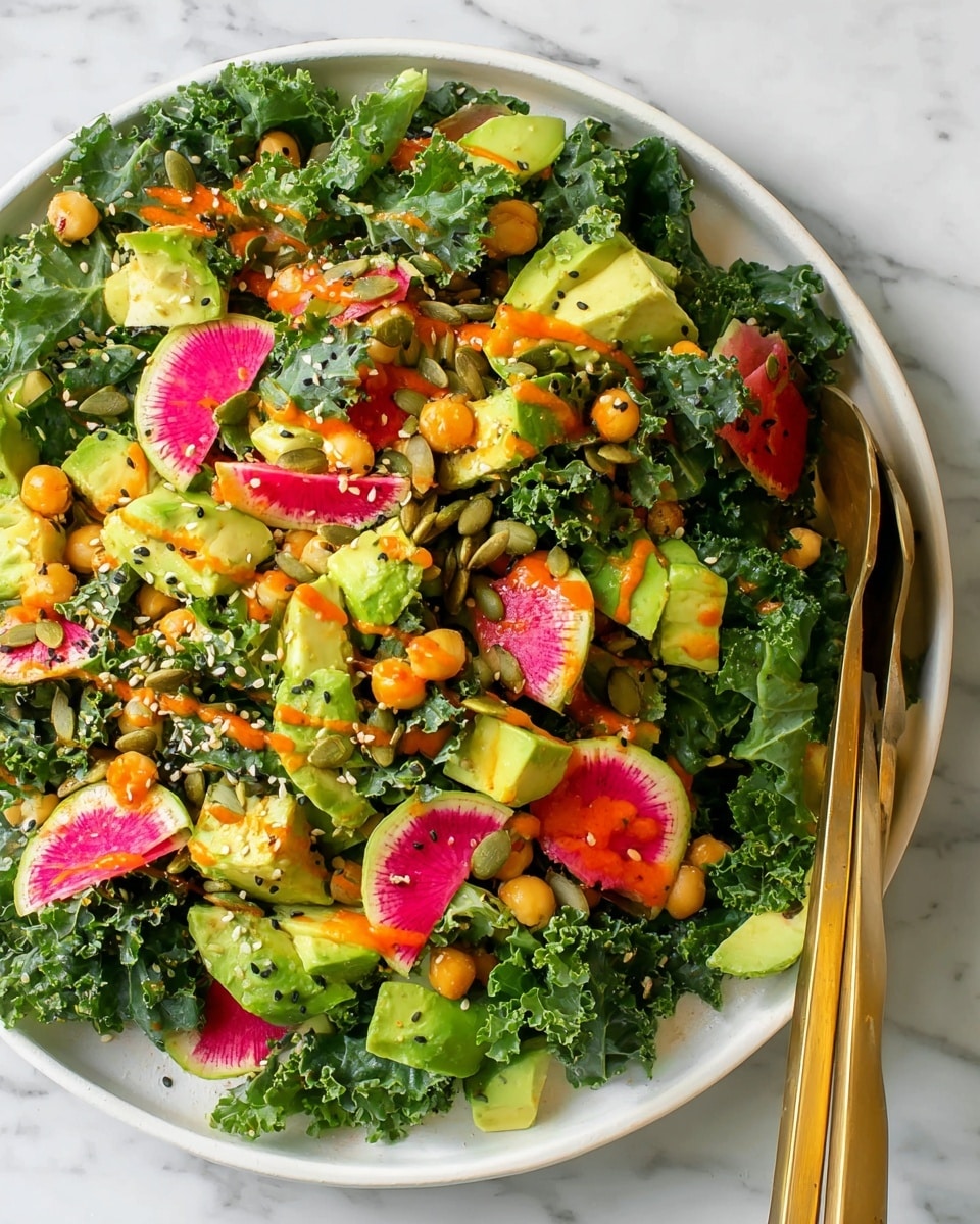 A fresh salad served in a white bowl on a white marbled surface, showing layers of dark green curly kale leaves as the base, topped with light green chunks of avocado scattered throughout. There are small round golden chickpeas spread over the salad, with thin slices of watermelon radish with green to pink gradient edges around the sides. Dark and light sesame seeds along with pumpkin seeds are sprinkled across the top, and a bright orange dressing drizzled unevenly on the salad adds a pop of color. Two gold serving tongs rest on the right side of the bowl. Photo taken with an iphone --ar 4:5 --v 7