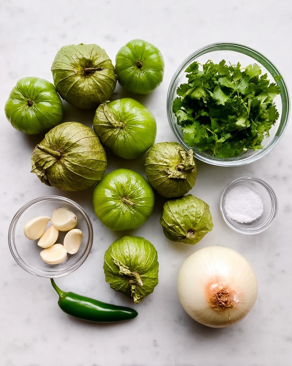 The image shows several fresh green tomatillos with their papery husks, arranged neatly on a white marbled surface. To the right, there is a small clear glass bowl filled with fresh green cilantro leaves, and next to it, a tiny clear bowl with coarse salt. Below the salt bowl are three peeled garlic cloves in another small clear bowl. A single shiny green chili pepper lies horizontally near a whole white onion with a light brown top. The items are spread out evenly with bright natural light, and the colors are fresh and vibrant. Photo taken with an iphone --ar 4:5 --v 7