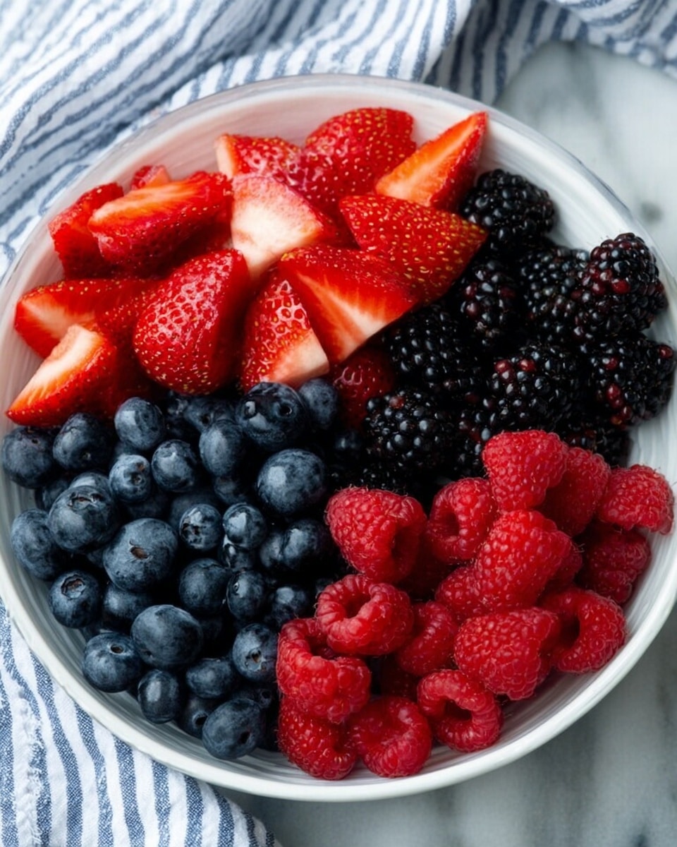 A white bowl shows four groups of fresh fruits neatly placed side by side: bright red strawberries cut in halves at the top, shiny blackberries on the right, vivid red raspberries at the bottom, and plump dark blue blueberries on the left. The bowl sits on a white marbled surface, with a soft blue and white striped cloth blurred in the background. The colors of the fruits are rich and bright, showing smooth and detailed textures of the berries’ skin and seeds. photo taken with an iphone --ar 4:5 --v 7