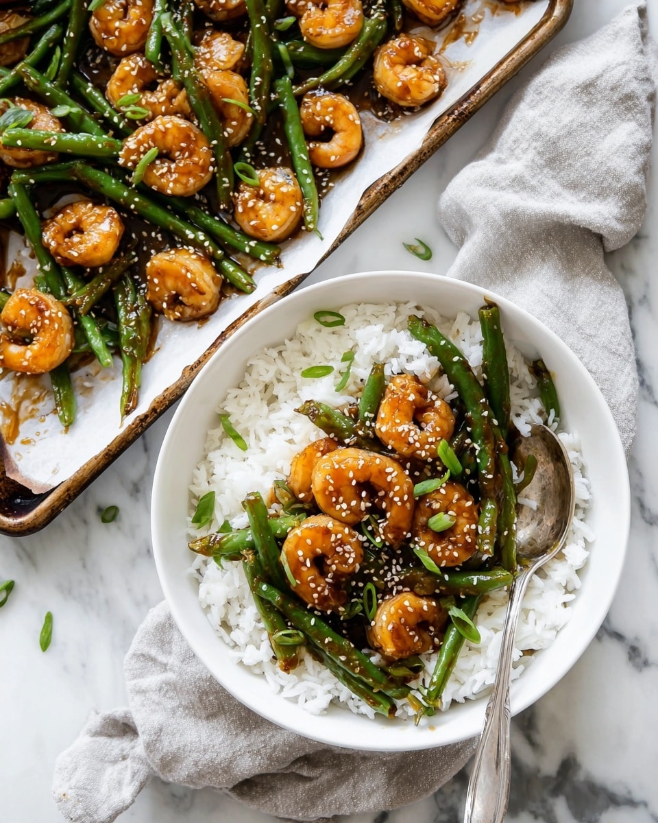 The image shows a white bowl filled with a base layer of fluffy white rice. On top of the rice, there is a layer of glossy shrimp with a light orange color mixed with green beans that are long and bright green. The shrimp and green beans are coated in a dark brown sauce and sprinkled with white sesame seeds and small green onion pieces. Next to the bowl is a white baking tray lined with parchment paper holding more shrimp and green beans with the same sauce and toppings. A silver spoon is placed in the bowl, and the scene is set on a white marbled surface with a light gray cloth partly under the baking tray. Photo taken with an iphone --ar 4:5 --v 7
