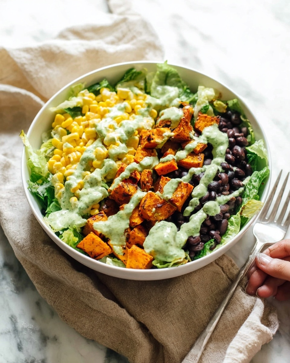 A white bowl holds a layered salad on a white marbled surface. The bottom layer is green leafy lettuce, topped with three sections: bright yellow corn kernels on the left, dark black beans on the right, and in the middle, orange roasted sweet potato cubes. A creamy green sauce is drizzled unevenly over the sweet potatoes and black beans, adding a textured contrast. Next to the bowl, a woman's hand holds a fork, and a beige cloth napkin is placed underneath the bowl. The background is bright with soft lighting. photo taken with an iphone --ar 4:5 --v 7